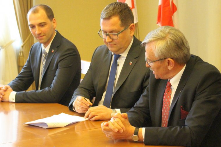 Prezydent Kalisza i rektor UAM składają podpisy pod aktem notarialnym